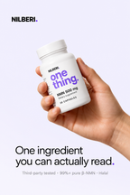 Hand holding a NILBERI NMN 500 mg bottle: one ingredient you can actually read