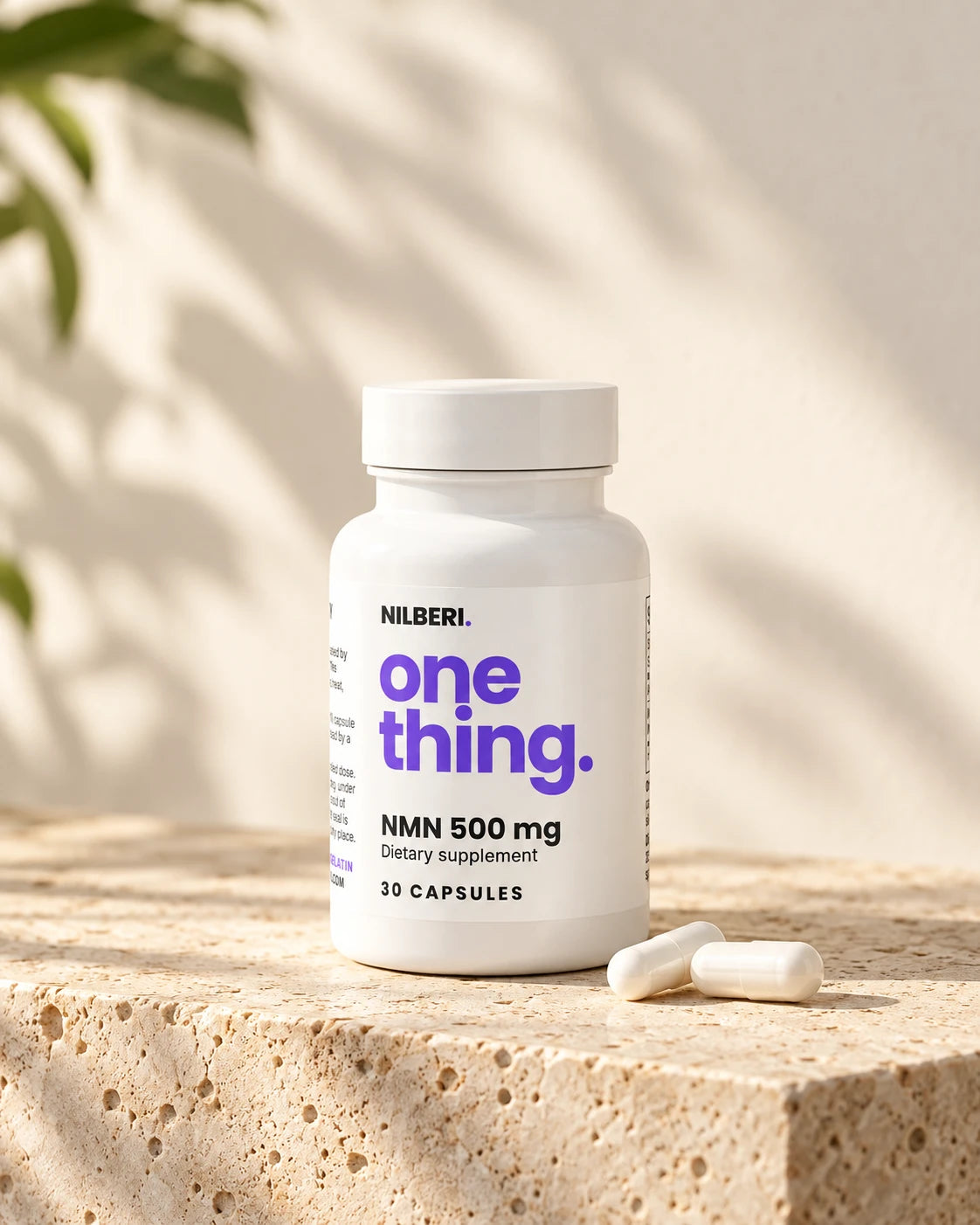 NILBERI NMN 500 mg bottle with two capsules on a travertine stone block in warm morning light